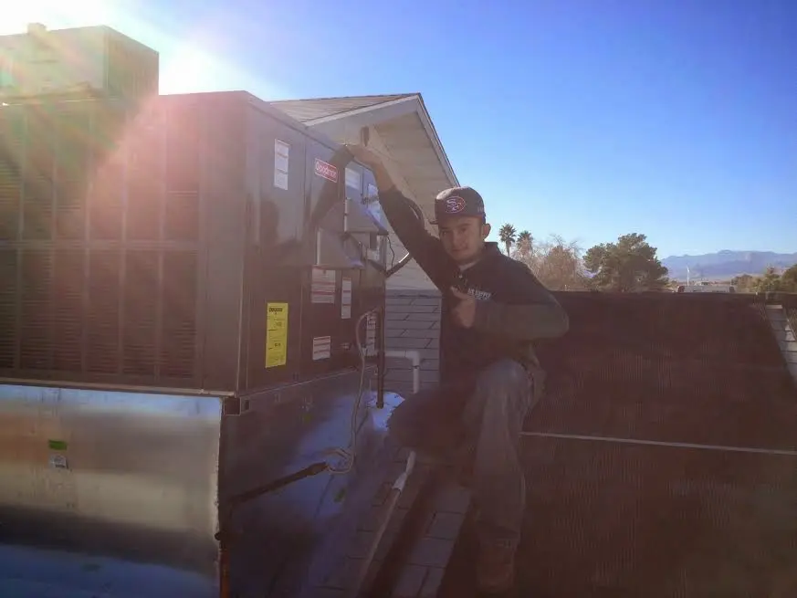 HVAC technician performing Heat Pump Repair on a rooftop unit in Ojai
